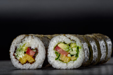 Sushi roll with rice, salmon, tuna fish, nori, avocado Japanese omelet