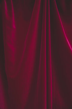 Detail of draped red velvet curtain with folds and creases