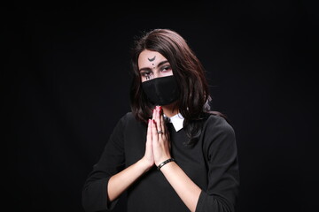 Obraz premium A girl with a face mask and a ghostly make up.