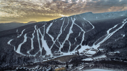 Aerial view to Stowe Mountain Ski Resort in Vermont, USA during sunset time, early winter 2020...