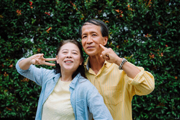 Funny and happy asian senior couple at park.