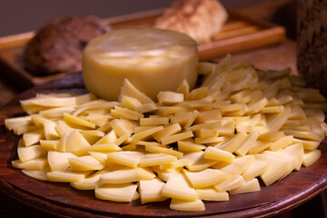 Sliced parmesan cheese on the wooden table.