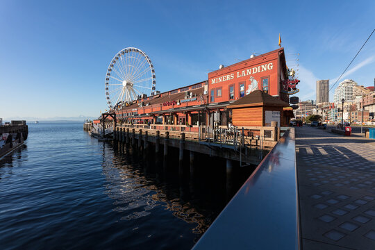 Miner's Landing at Pier 57 and the Great Wheel on the Elliot Bay waterfront under a clear blue sky on December, 3, 2020 in Seattle, Washington.