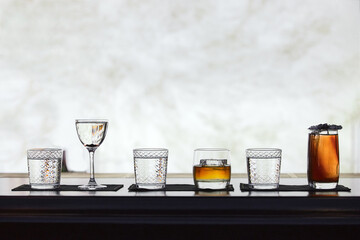 Row of different simple cocktail drinks, darker themes