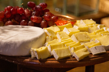 Brie cheese with guava jam on the wooden board.