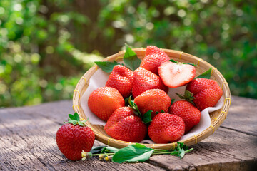 Fresh strawberries in a wooden bowl on blur garden background, Red Strawberries in Bamboo basket.