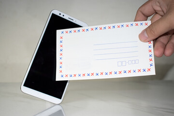 Man holding paper envelope In front of a smartphone mockup