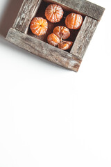 tangerines with fresh leaves in wooden box isolated on white, isolated on a white, top view