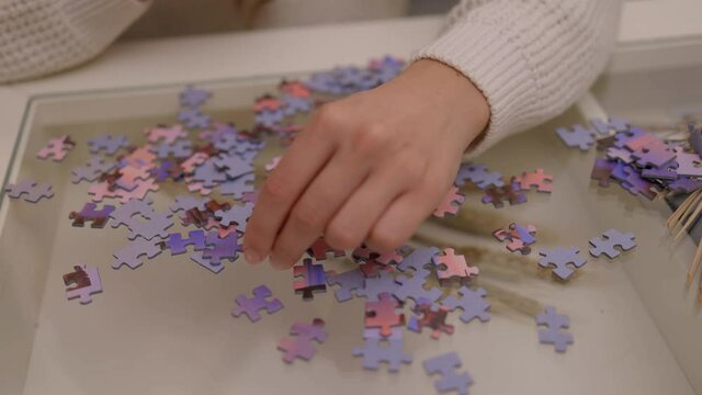 Young woman spends time with puzzles - videoclip