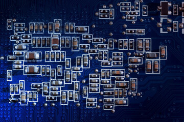 Close-up of a set of components and controls on a printed circuit board (PCB) with stripes of conductors between a transistor and an electronic processor. IT technologies in abstract background