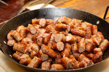 Barbecue sausage chopped into large pan. Brazilian barbecue.