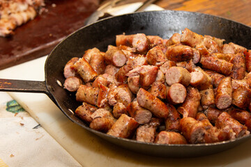 Barbecue sausage chopped into large pan. Brazilian barbecue.