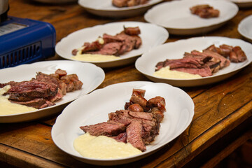 Barbecue with anchovy meat and sausage served with aligot.