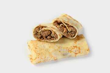 Savory pancake rolls stuffed with ground meat. White background, copy space. One pancake is shown in the section with the filling. The concept of food delivery services