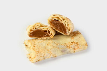 Pancakes with condensed milk on a light background. One pancake is cut in two to show the filling. food delivery