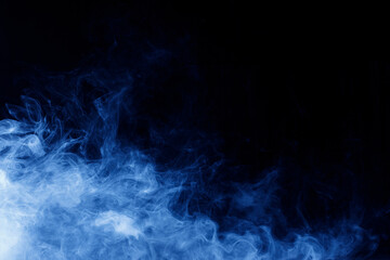 Fototapeta premium Abstract blue smoke moves on black background. Swirling smoke.