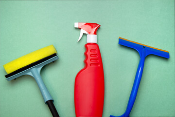 Dishwashing equipment: detergent and brushes for cleaning windows on a green background