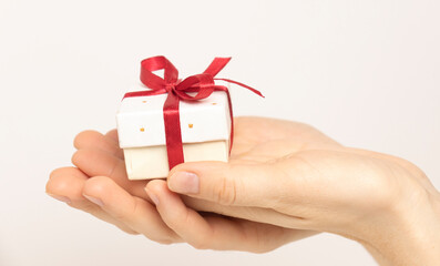 Female hands holding a luxury small gift box. isolated on white background. Christmas and New Year's day. Mock up template ready for your design.
