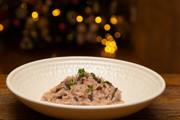 Mushroom risotto on the wooden table on christmas background.