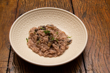 Mushroom risotto, on the wooden table.