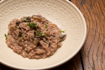 Mushroom risotto, on the wooden table.