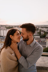 Close up portrait, man and woman smiling to each other on sunset with city in background. Couple romantic intimate moments
