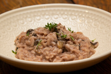 Mushroom risotto, on the wooden table.