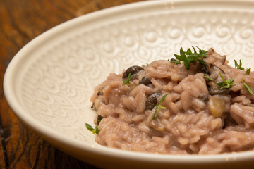Mushroom risotto, on the wooden table.