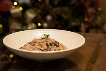 Mushroom risotto on the wooden table on christmas background.