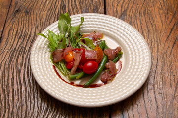 Nicoise salad - salad made with arugula, chopped tomatoes and anchovies.