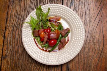Nicoise salad - salad made with arugula, chopped tomatoes and anchovies.