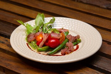 Nicoise salad - salad made with arugula, chopped tomatoes and anchovies.