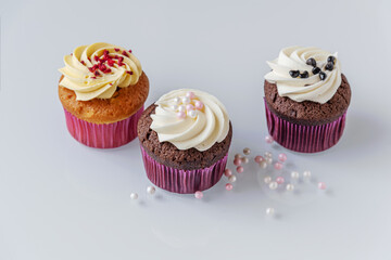 assorted cupcakes and decor for them on a light glass surface close up