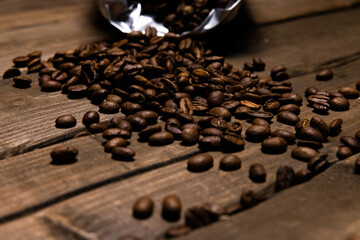 scattered coffee beans in a bag on a wooden background
