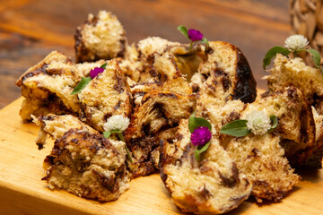 Delicious slices of panettone with candied fruit on the wooden board.