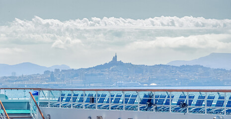 Vue du pont piscine et des transats d'un navire de croisière en escale au terminal du port de Marseille.