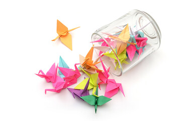 origami paper birds spilling out of glass cup
