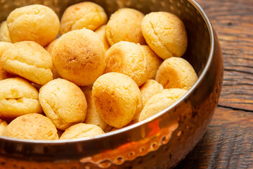Brazilian cheese bread in a pan on wooden table.