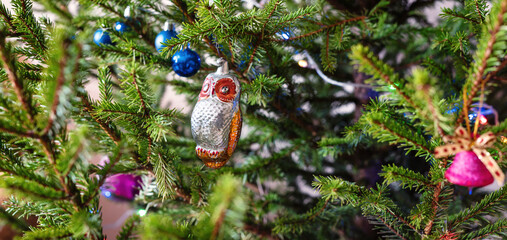 Vintage toy owl decoration on the Christmas tree, background.