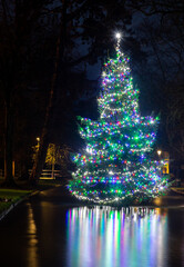 Long exposure image of the the Christmas tree at Bourton-on-the-Water in The Cotswolds reflecting in the river.