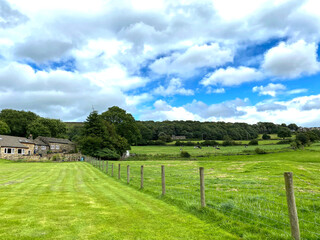 Fototapeta na wymiar Landscape, with extensive meadows, farm buildings, and trees on the horizon near, Bingley, Bradford, UK