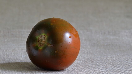 
Beautiful red delicious juicy tomato on a linen tablecloth