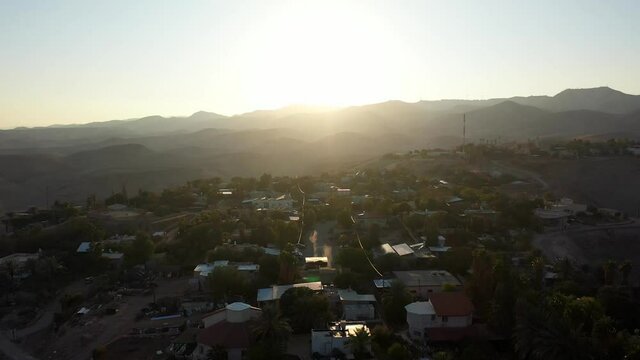 Small village in the desert at sunset, aerial view
drone view Palm trees Mountains and red rofftops,vered yericho, Israel
