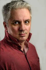 Fototapeta premium Portrait of a casual Caucasian Businessman in his forties dressing for work in a coral flower colored shirt