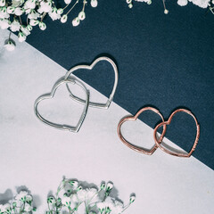 Joyería, aretes, corazones, fondo blanco y azul 