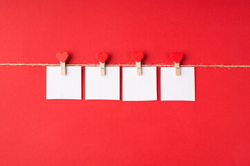 I love you concept. Close up flat lay view photo of pins with small hearts holding four cards with letters love isolated bright color red background