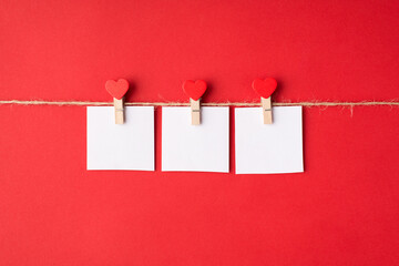 Photo of three paper cards with words i love you hanging with pins on rope string isolated bright color red backdrop