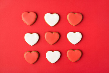 Layout flatlay close up above overhead view photo of yummy white and red bright color cookies in shape of hearts isolated bright color backdrop