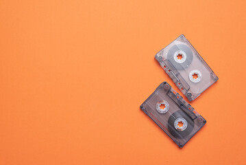 Old retro stereo cassette on the orange flat lay background.
