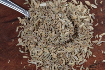 fennel seeds in spoon on wooden table